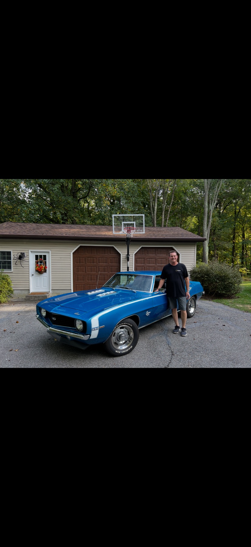Jim standing beside his LeMans Blue 1969 Camaro
